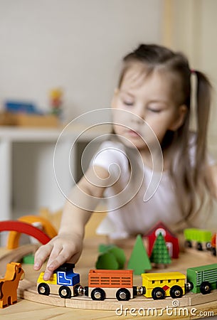 Montessori material. Daughter learn transport through the game. Wooden railroad Stock Photo