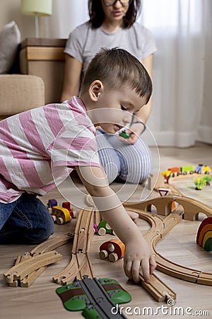 Montessori material. Mom and son learn transport through the game. Wooden railroad Stock Photo