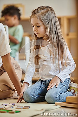Montessori school, cute girl sitting near Stock Photo