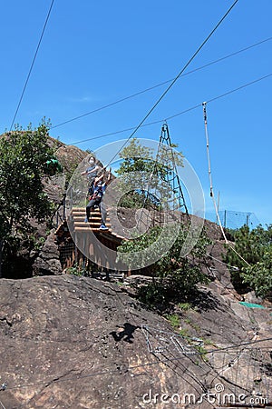 Montestrutto, Italian alps - June 2020: a girl throws herself into a rope-smeared cliff in an adventure park Editorial Stock Photo