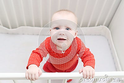 6 month baby girl crying in white bed Stock Photo