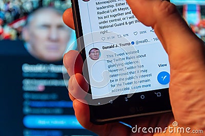 Smartphone showing Twitter covering Trump tweet with warning label for â€œglorifying violence Editorial Stock Photo