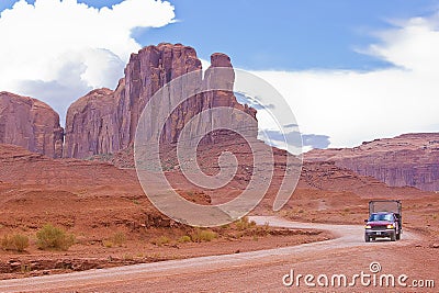 The Monument Valley in Utahâ€“Arizona state with the red earth desert, winding country road and Pick-up truck Editorial Stock Photo