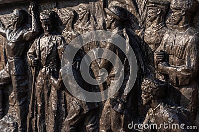 Monument of working people executed in brown stone Stock Photo