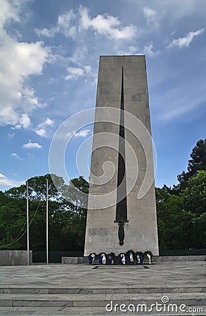 Monument of World War II with wreaths in Komotini, East Macedonia, Greece. Impressive tall stone tower with a sword Editorial Stock Photo