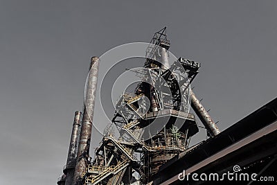 Monumental view of old steel mill with descending stairway, smokestacks Stock Photo