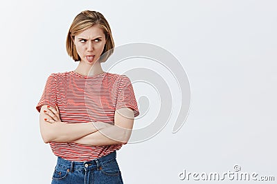 Moody childish woman being offended, sulking and expressing disappointment, standing displeased, frowning and staring Stock Photo