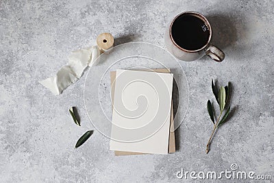 Moody feminine wedding stationery mock-up scene. Blank greeting card, cup of coffee and green olive leaves, branches Stock Photo