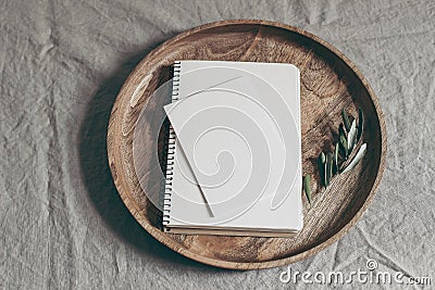 Moody feminine wedding stationery mock-up scene. Blank greeting card, notepad and green olive branch on wooden tray Stock Photo