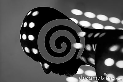 Silhouette of a man with holes of light curving around his body. Stock Photo