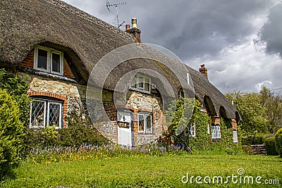 Moody skies above a thatched cottage in Dorset, England. Stock Photo