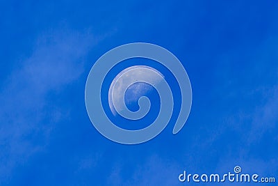 The moon in a bright blue daylight sky Stock Photo