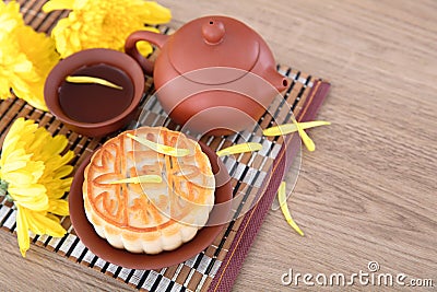 Moon cakes, tea and golden chrysanthemums for the Chinese Mid-Autumn Festival.Chinese characters on the moon cake means `Five kind Stock Photo