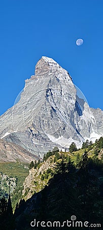The Moon next to the Matterhorn peak on a sunny day, Switzerland. Stock Photo