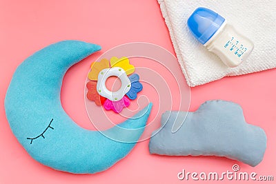 Moon pillow, clouds, baby bottle and toys for put newborn in bed on pink background top view Stock Photo