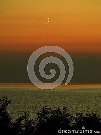 Moon set and orange sky after sunset Stock Photo