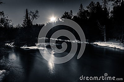 Moonlight Reflection over Winter River Snow on Banks Stock Photo