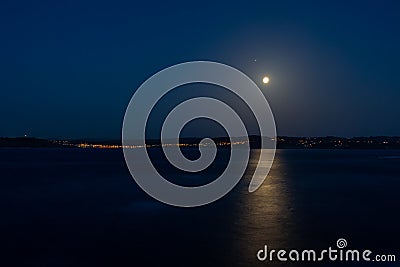 Moonlit Walkway. Reflection of the moon on the water Stock Photo