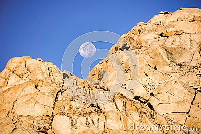 Moonset behind a rocky mountain at sunrise, Eastern Sierra Mountains, Mount Whitney Trail,California Stock Photo