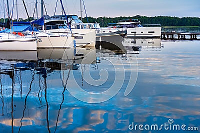 Moored sailboats on a pier calm early morning Stock Photo