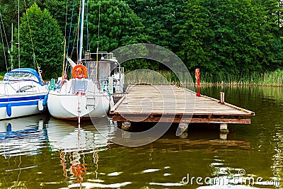 Moored sailboats on a pier calm early morning Stock Photo