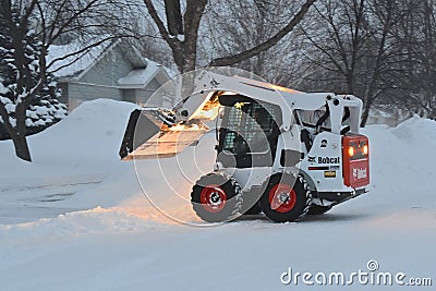 Bobcat skid steer removing snow Editorial Stock Photo