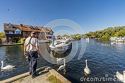 Tourist mooring a hire boat on the Norfolk Broads Editorial Stock Photo