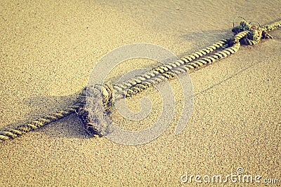 Mooring rope with knots on fine sand in morning (vintage style) Stock Photo