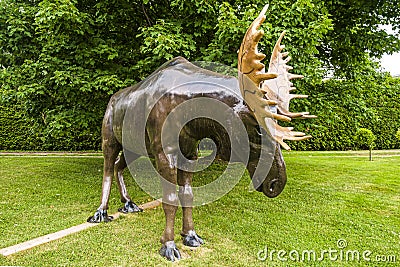 Moose sculpture beside a countryside road before a forest Editorial Stock Photo