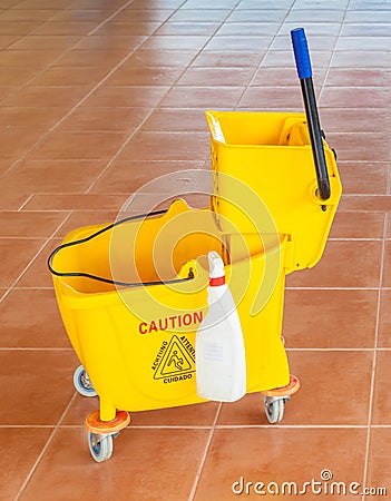 Mop bucket and wringer with caution sign on the floor Stock Photo