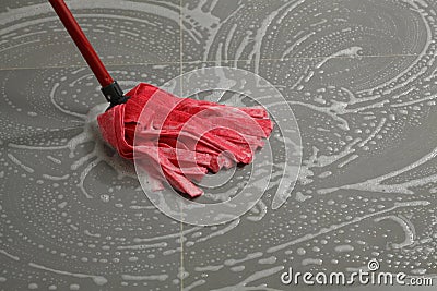 Mopping the floor tiles Stock Photo