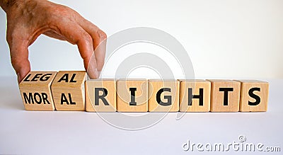 Moral or legal rights symbol. Businessman turns wooden cubes and changes words moral rights to legal rights on a beautiful white Stock Photo