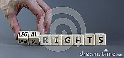 Moral or legal rights symbol. Businessman turns wooden cubes and changes words moral rights to legal rights on a beautiful grey Stock Photo