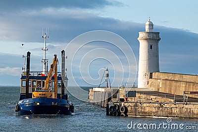 This is the Moray Council owned Dredger boat called Selkie arriving back at Buckie Editorial Stock Photo