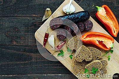 Morcillo Spanish black pudding, blood sausage, cutting slices, black rye bread in a heart shape, pepper, garlic Stock Photo