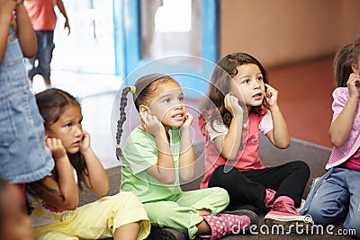 The more you learn, the more you shall succeed. You pre-school children sitting on the mat of the room touching their Stock Photo