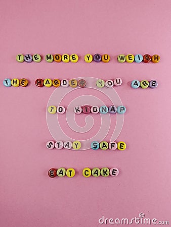 The more you weigh the harder you are to kidnap stay safe eat cake funny sign with colorful letters on a pink background Stock Photo