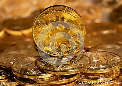 Single Bitcoin coin standing on top of other gold coins Editorial Stock Photo