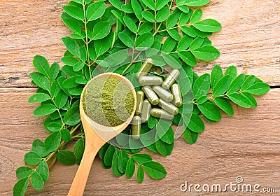 moringa leaf and powder capsule on wooden background Stock Photo