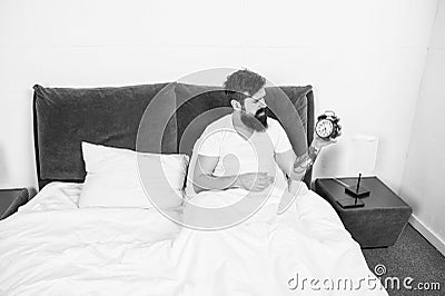 Morning again. Stressful man wake up turn off alarm clock. Time to wakeup. Unhappy handsome man in bed. Man suffering on Stock Photo