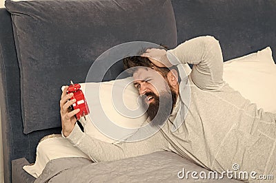 Morning awakening. Man awake unhappy with alarm clock ringing. Although you are asleep you may wake up feeling like did Stock Photo