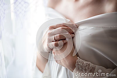 Morning bride. A beautiful girl with a white veil on her head stands near the window. Wedding portrait for the bride. Boudoir Stock Photo