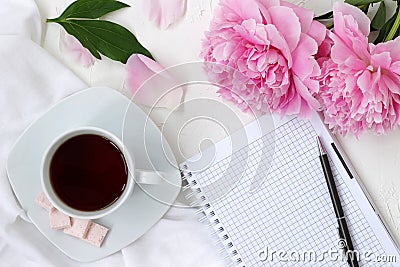 Morning coffee cup and notepad in bright colours with pink flowers Stock Photo