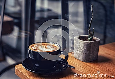 Morning coffee in a black cup on wooden table Stock Photo