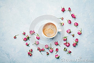 Morning coffee cup and dry rose flowers on blue vintage table top view in flat lay style. Cozy breakfast on Mother or Woman day. Stock Photo