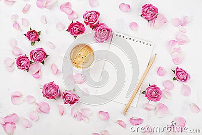 Morning coffee mug for breakfast, empty notebook, petal and pink rose flowers on white table top view in flat lay style. Stock Photo