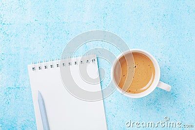 Morning coffee, pencil and clean notebook on blue pastel table top view. Flat lay style. Planning and design concept for blogging. Stock Photo