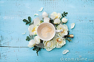 Morning cup of coffee and beautiful roses flowers on turquoise rustic table top view. Cozy Breakfast. Flat lay style. Stock Photo