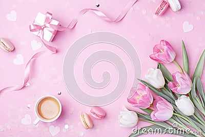 Morning cup of coffee, cake macaron, gift or present box and spring tulip flowers on pink. Breakfast for Women, Mother day Stock Photo