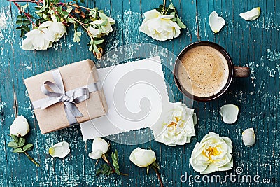 Morning cup of coffee, gift box, notes and beautiful roses flowers on teal vintage background top view. Cozy Breakfast. Flat lay. Stock Photo